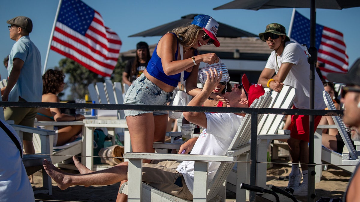 Woman pours a drink on beach